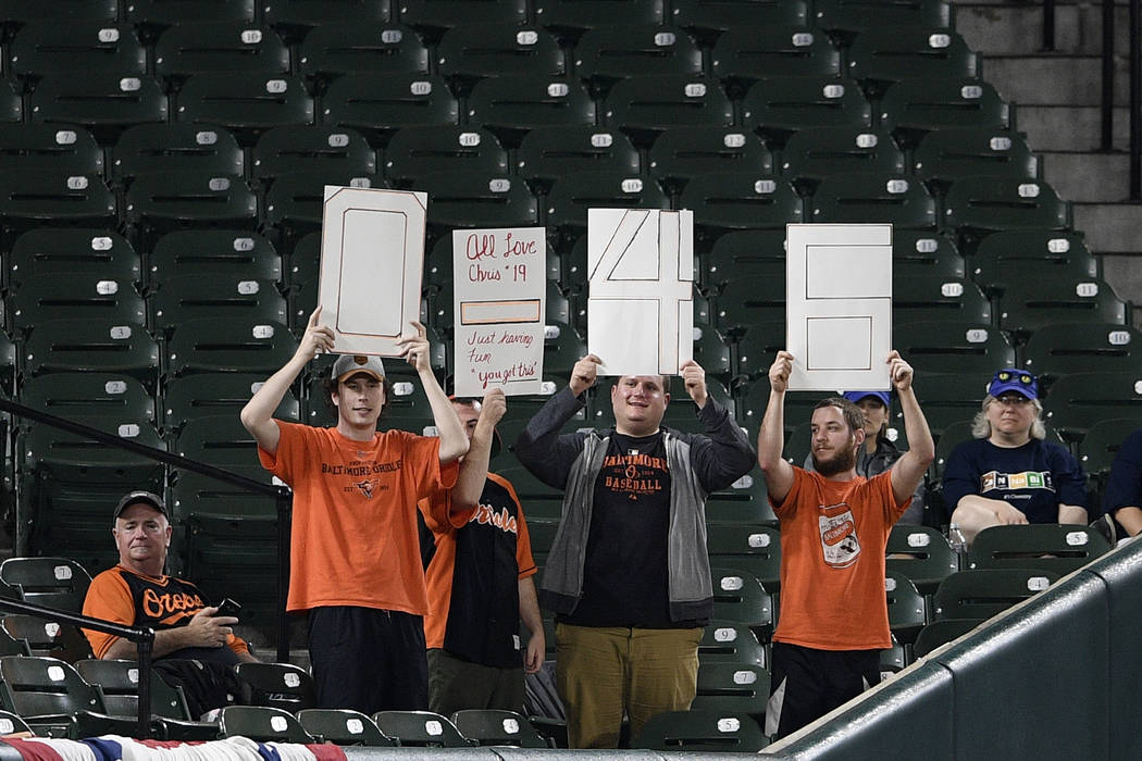 Fans hold up a signs referring to Baltimore Orioles' Chris Davis during the fifth inning of a b ...