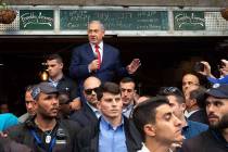 Israeli Prime Minister Benjamin Netanyahu escorted by bodyguards speaks during a visit to the m ...