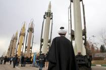 An Iranian clergyman looks at domestically built surface to surface missiles displayed by the R ...