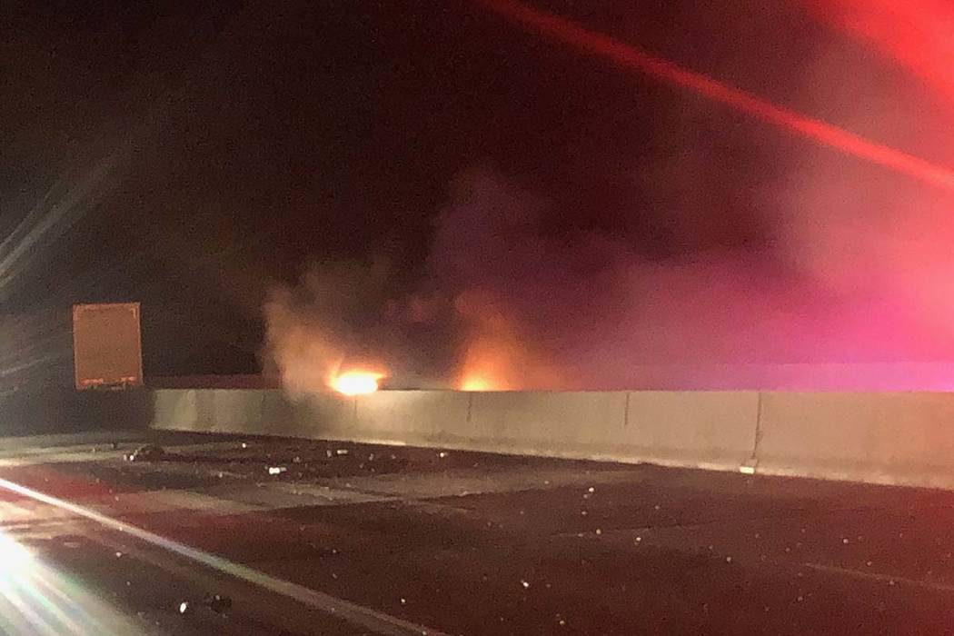A vehicle burns as first responders arrive at a two-vehicle crash just a mile north of the Hoov ...