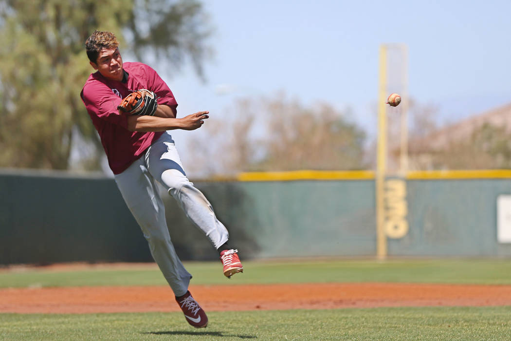 Desert Oasis senior Aaron Roberts, 18, throws a ball to first base during a team practice at De ...