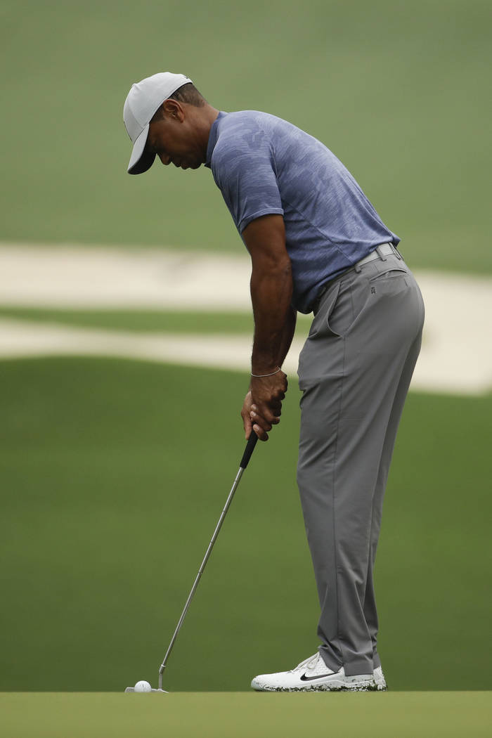 Tiger Woods putts on the 10th hole during a practice round for the Masters golf tournament Mond ...