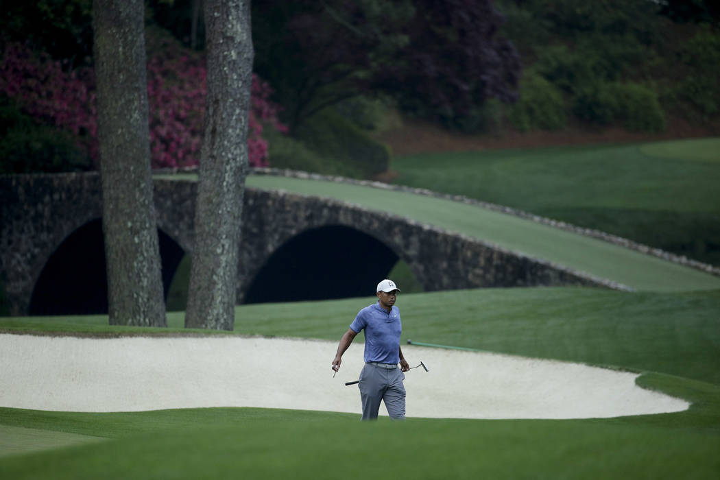 Tiger Woods walks off the 11th green during a practice round for the Masters golf tournament Mo ...