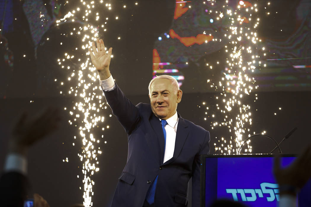 Israel's Prime Minister Benjamin Netanyahu waves to his supporters after polls for Israel's gen ...