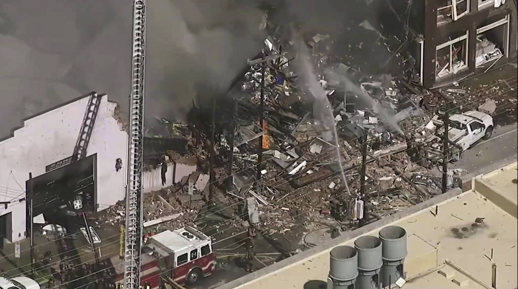 In this image taken from video firefighters and emergency officials respond to an explosion and ...