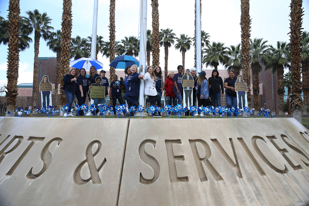 Volunteers are photographed after planting 450 pinwheels outside of the Eighth Judicial Distric ...