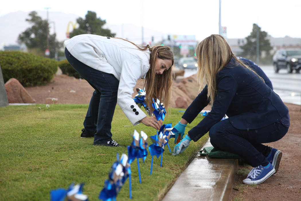 Volunteers Rochelle Vannoy, left, and Heather McCusker, plant pinwheels outside of the Eighth J ...