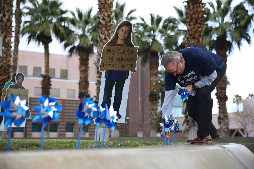 District Judge Bryce Duckworth plants pinwheels outside of the Eighth Judicial District Family ...