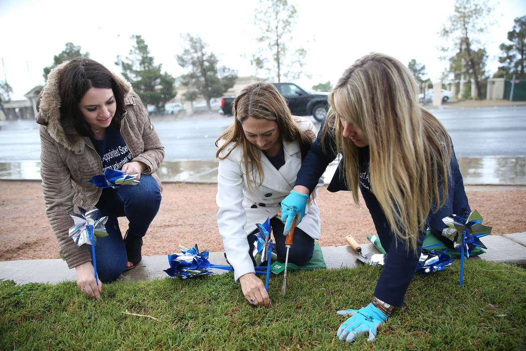 Volunteers from left, Lisa Coruzzi, Rochelle Vannoy, and Heather McCusker, plant pinwheels outs ...