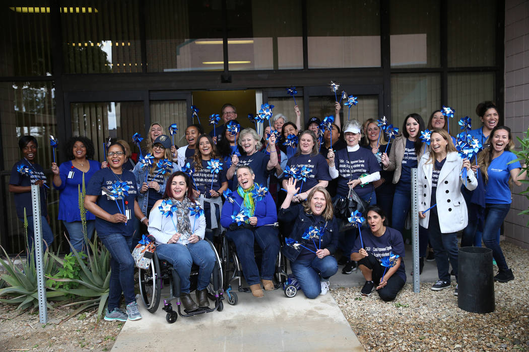 Volunteers are photographed before planting 450 pinwheels outside of the Eighth Judicial Distri ...