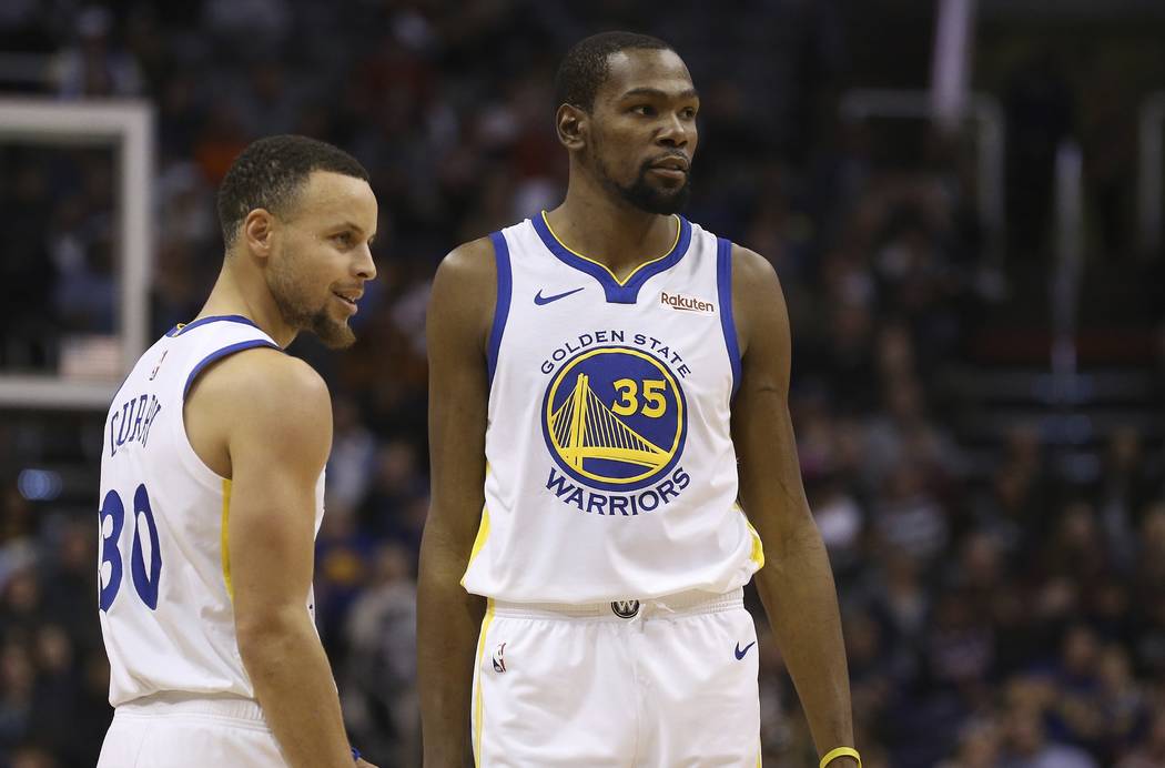 Golden State Warriors guard Stephen Curry (30) and forward Kevin Durant (35) pause during the f ...