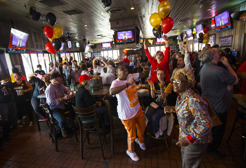 Las Vegas Aces fans, including "Gee" Brown, center, celebrate after Jackie Young of N ...