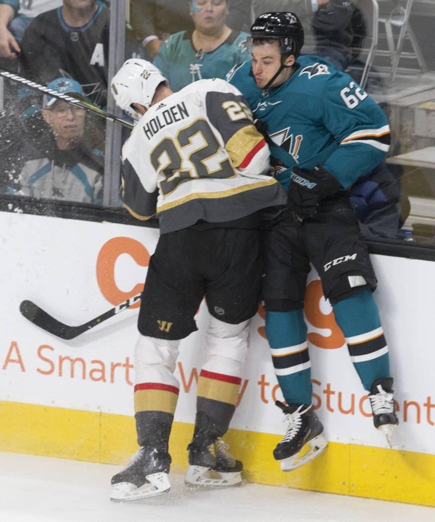 Golden Knights defenseman Nick Holden (22) collides with San Jose Sharks right wing Kevin Laban ...