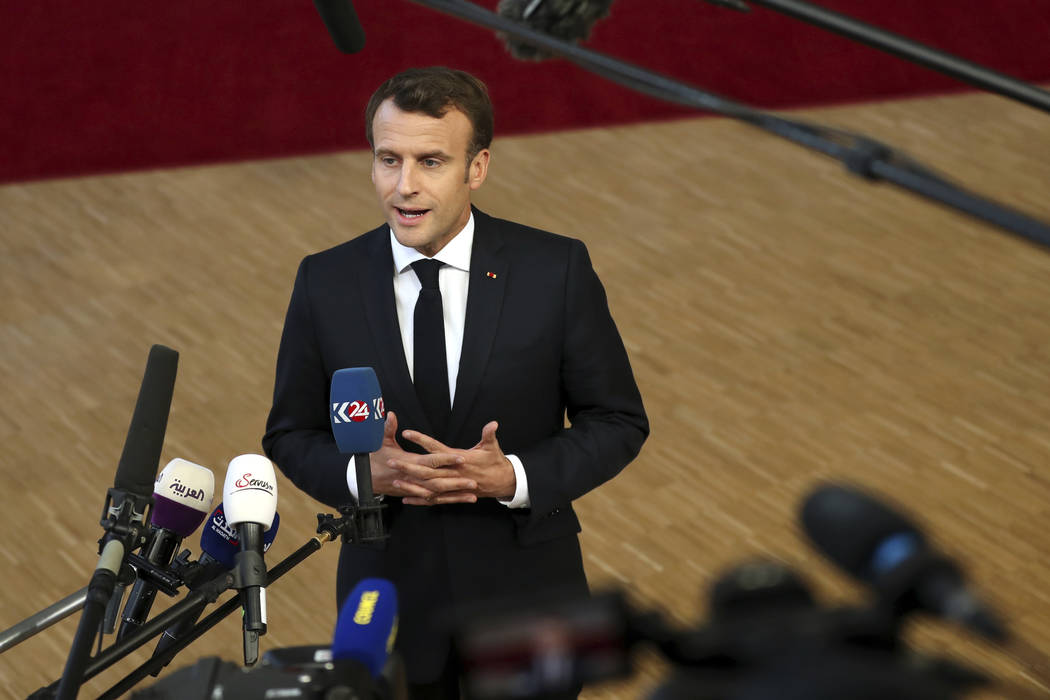 French President Emmanuel Macron speaks with the media as he arrives for an EU summit at the Eu ...