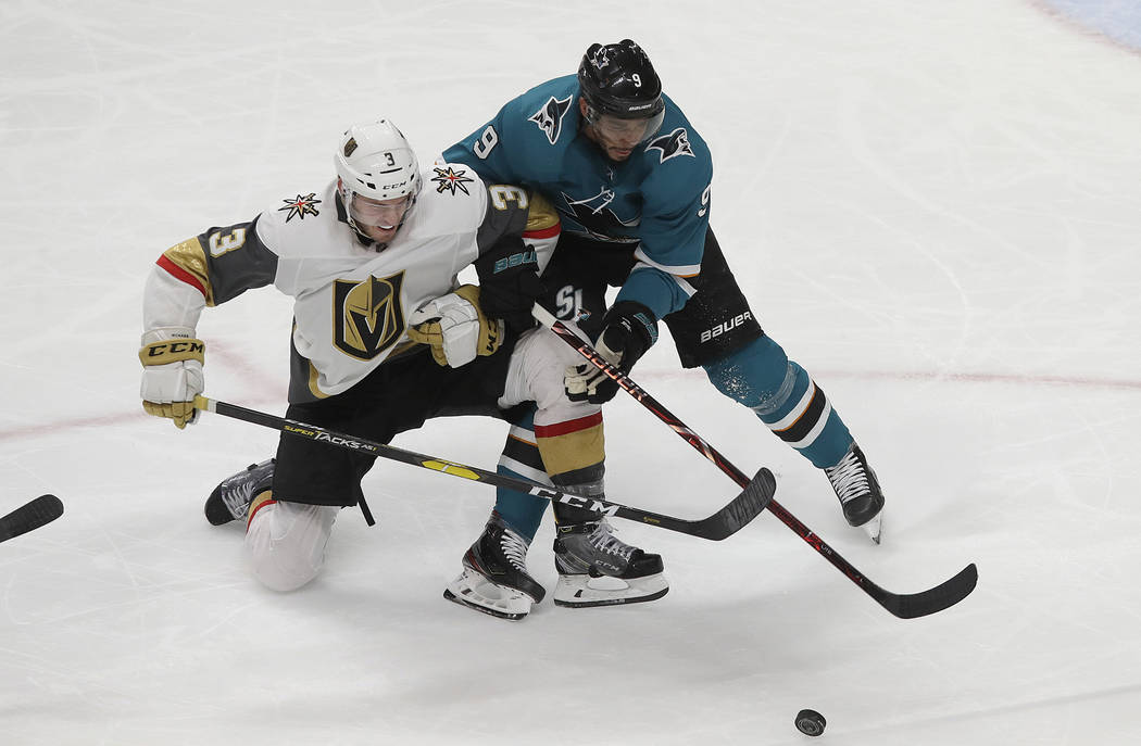 San Jose Sharks left wing Evander Kane, right, reaches for the puck next to Vegas Golden Knight ...