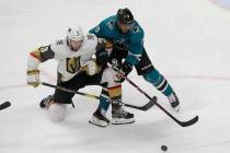 San Jose Sharks left wing Evander Kane, right, reaches for the puck next to Vegas Golden Knight ...