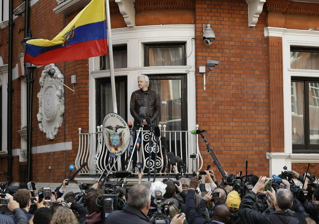 Watched by the media WikiLeaks founder Julian Assange looks out from the balcony of the Ecuador ...
