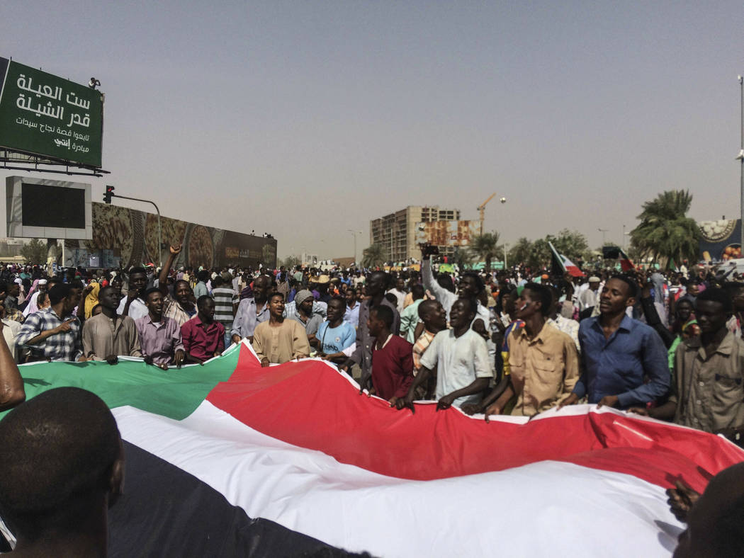 Sudanese celebrate after officials said the military had forced longtime autocratic President O ...