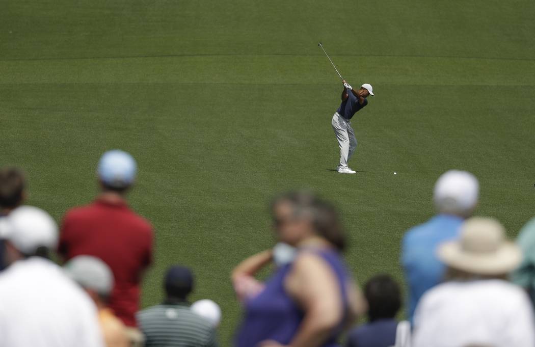 Tiger Woods hits on the eighth hole during the first round for the Masters golf tournament Thur ...