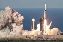 A SpaceX Heavy rocket carrying a communication satellite lifts off from pad 39A at the Kennedy ...