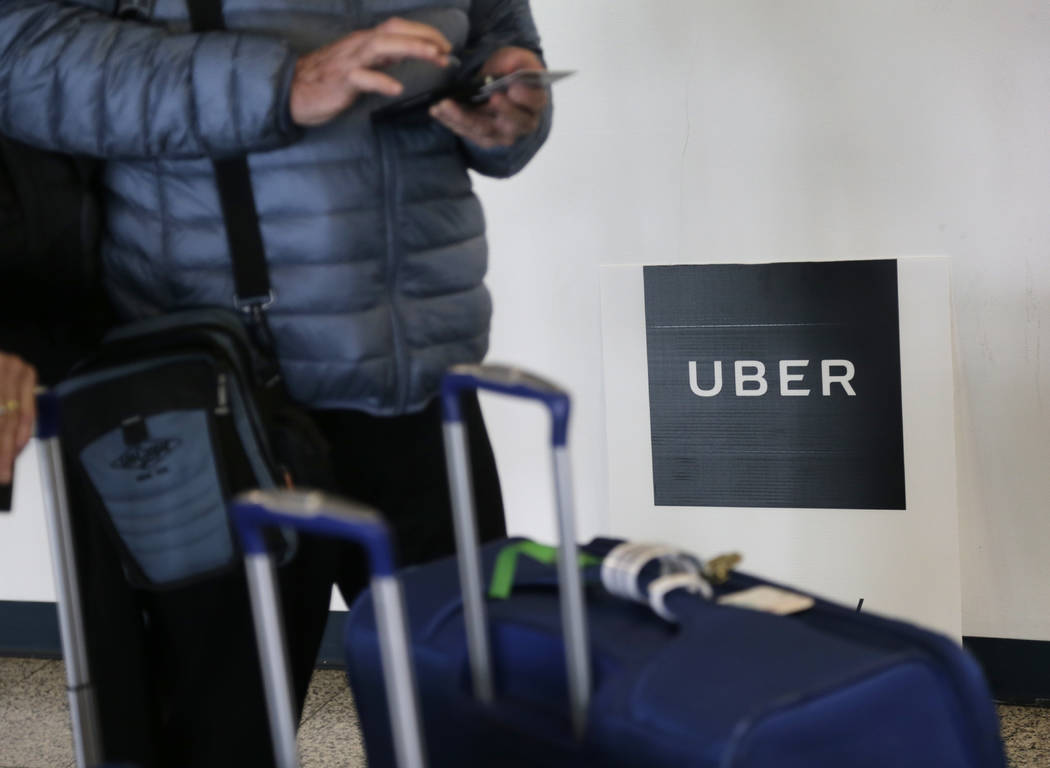 FILE - In this March 15, 2017, file photo, a traveler tries to book a ride with Uber at LaGuard ...