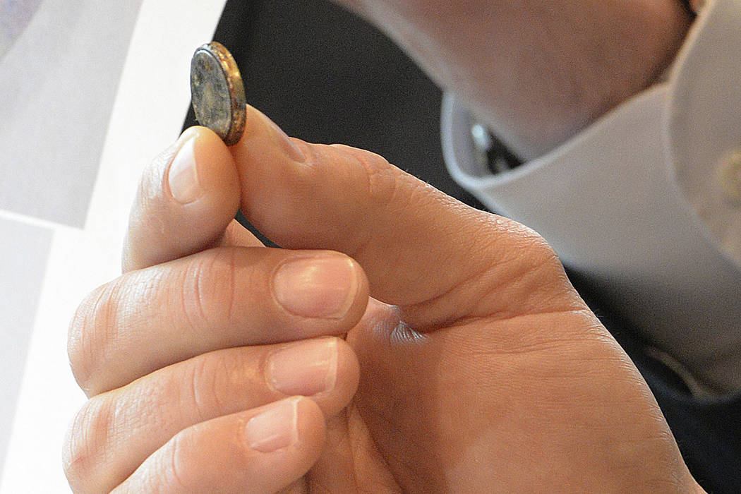 A lawyer holds a battery that was removed Dec. 21, 2016, rom a toddler's esophagus at a news co ...