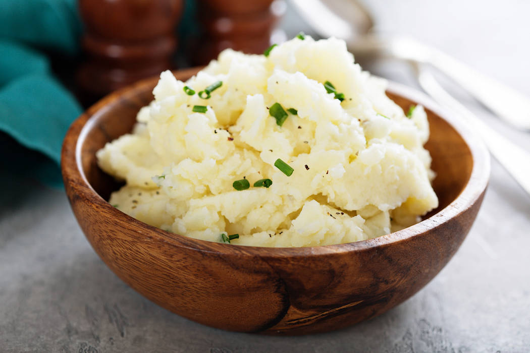 Fluffy mashed potatoes with chives in a wooden bowl (Getty Images)