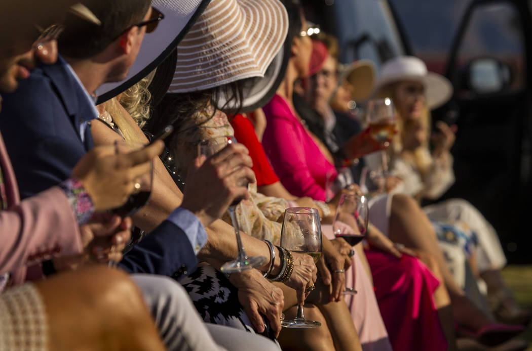 Guests enjoy tasty beverages as they watch Saks Fifth Avenue featuring a formal runway show of ...
