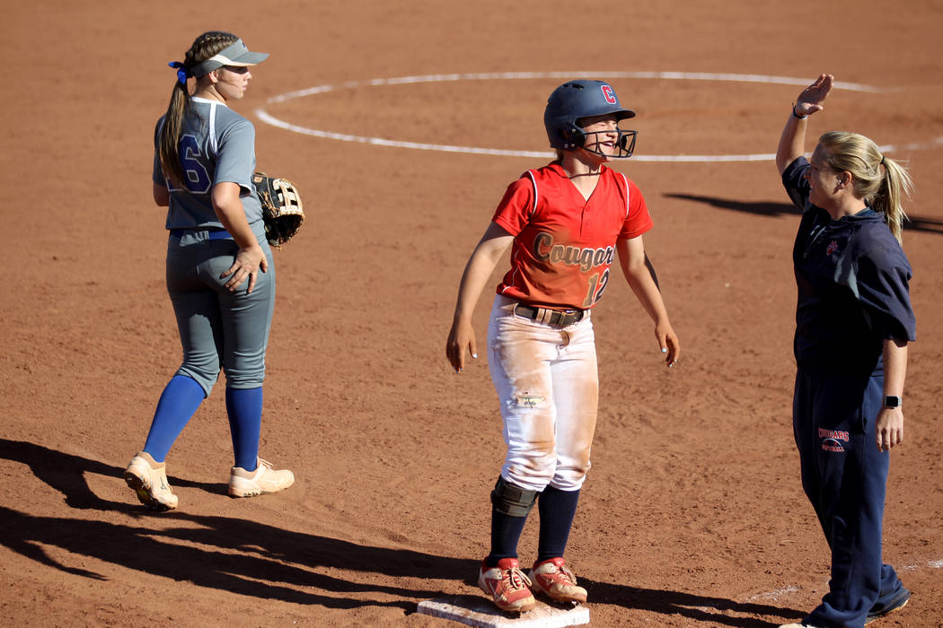 Coronado baserunner Paige Sinicki (12) gets a high five from coach Melissa Krueger on third bas ...