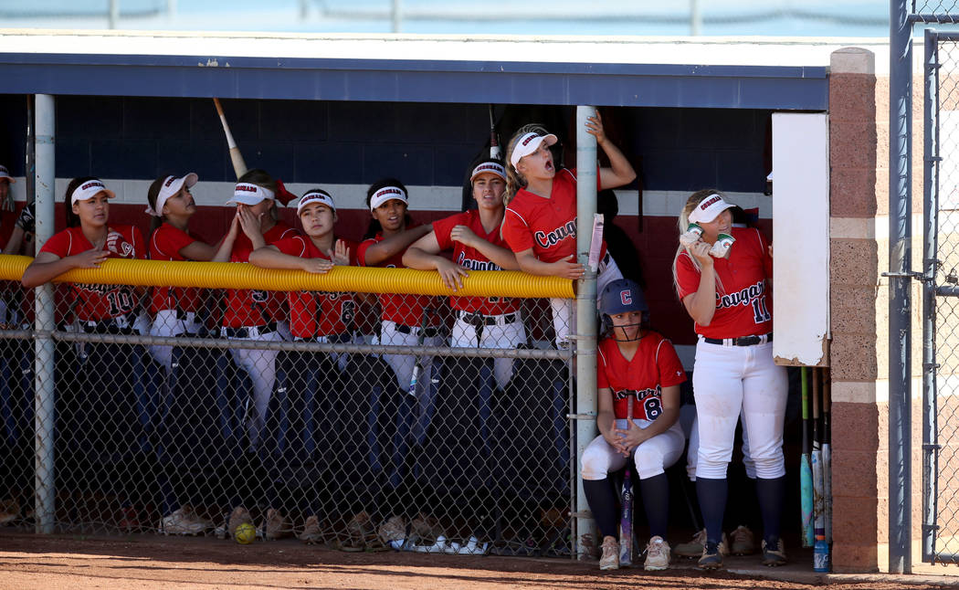 Coronado's Paige Sinicki (12), standing on chair, cheers with her teammates in the first inning ...