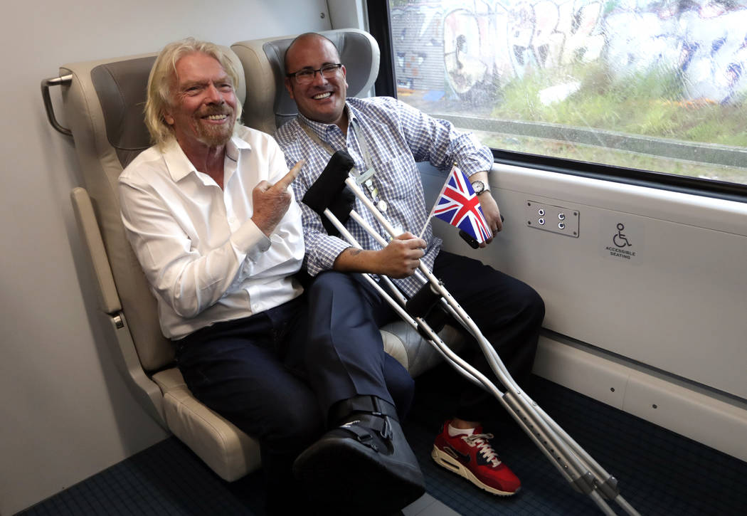 Richard Branson, of Virgin Group, left, sits with a passenger while riding a Brightline train f ...