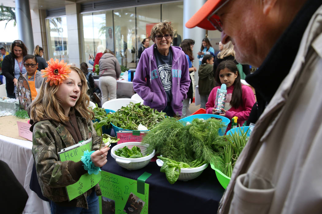 Goynes Elementary School student Juliet Robertson, 10, offers samples of mint leaf to customers ...