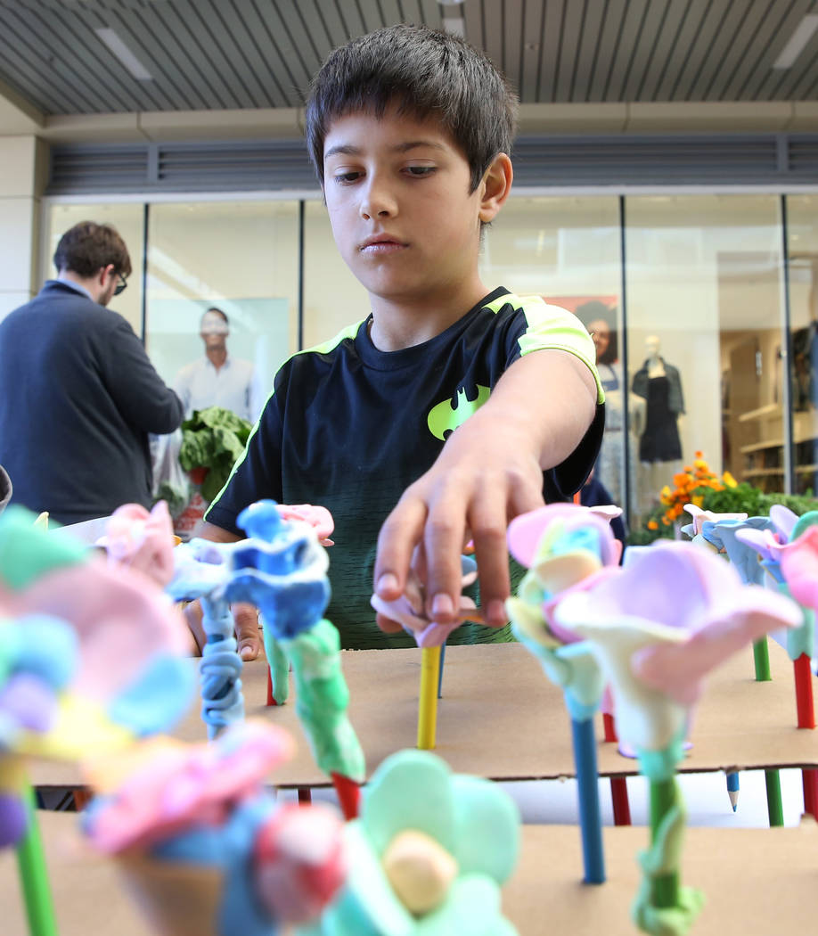 Taylor Elementary School student Richard Estrada, 9, displays flowers made out of clay at Green ...