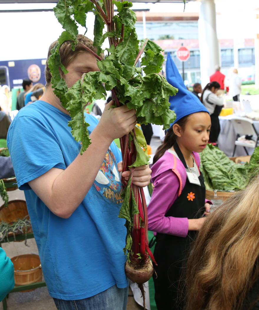 Aaron Berkowitz holds his giant beet he bought at Green Our Planet's Giant Student Farmers Mark ...