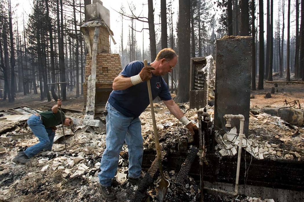 In this 2007 photo, men clear debris after the Angora Fire destroyed hundreds of Tahoe-area hom ...