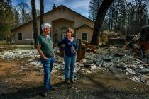 In this March 19, 2019 photo, Oney and Donna Carrell stand near the ashes of her father's house ...