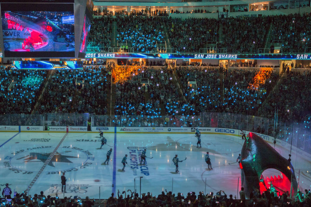 San Jose players circle the ice after entering through a massive shark head, right/bottom, at S ...