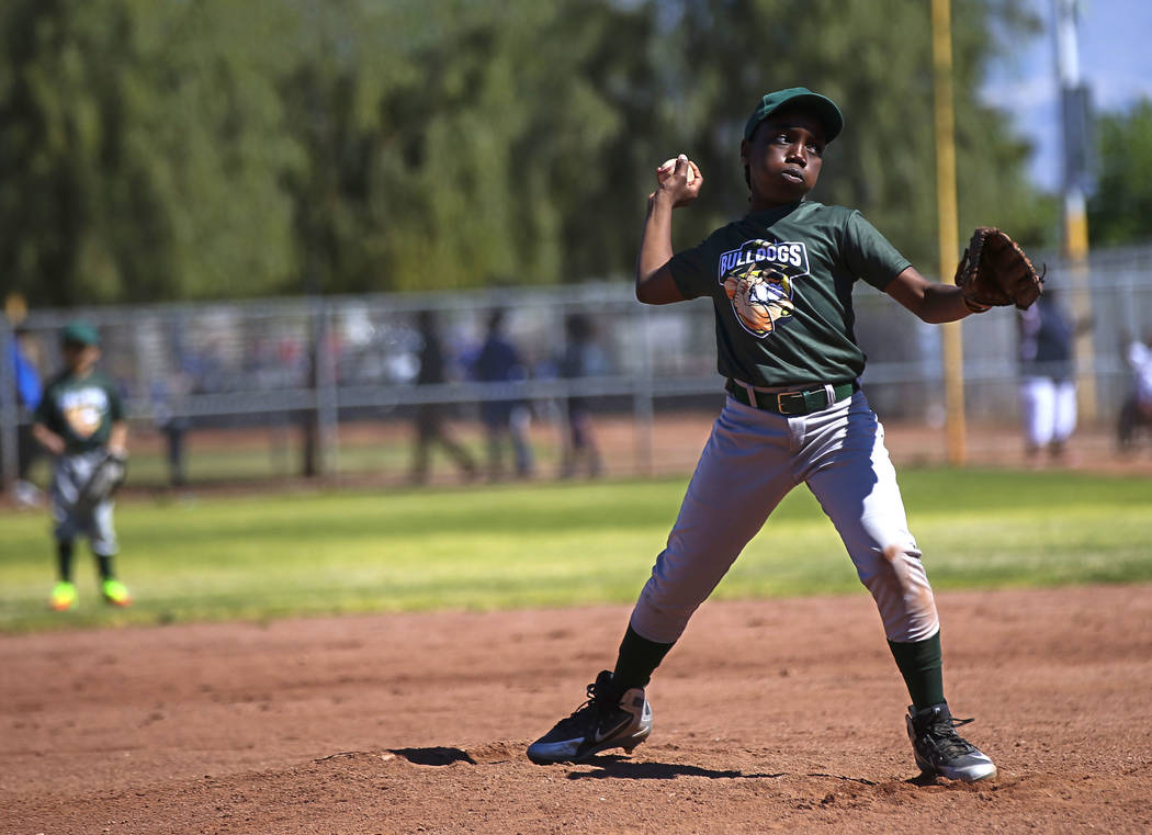 Bulldogs pitcher Marcel Elzy, 12, throws to the Rangers during the opening day celebration for ...