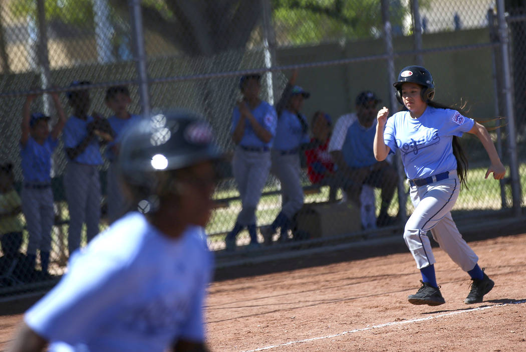 Royals' Natalia Zuniga heads for home plate to score against the Rockies during the opening day ...