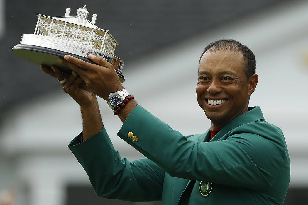 Tiger Woods wears his green jacket holding the winning trophy after the final round for the Mas ...