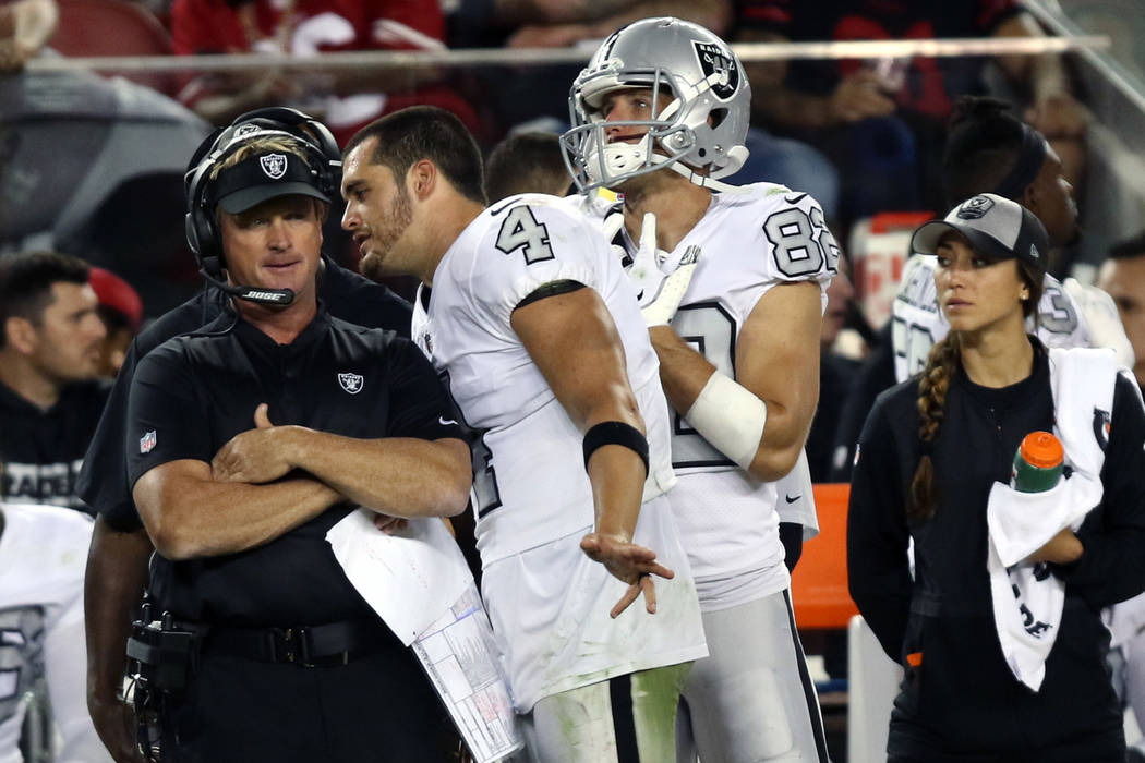 Oakland Raiders quarterback Derek Carr (4) speaks to head coach Jon Gruden after being benched ...