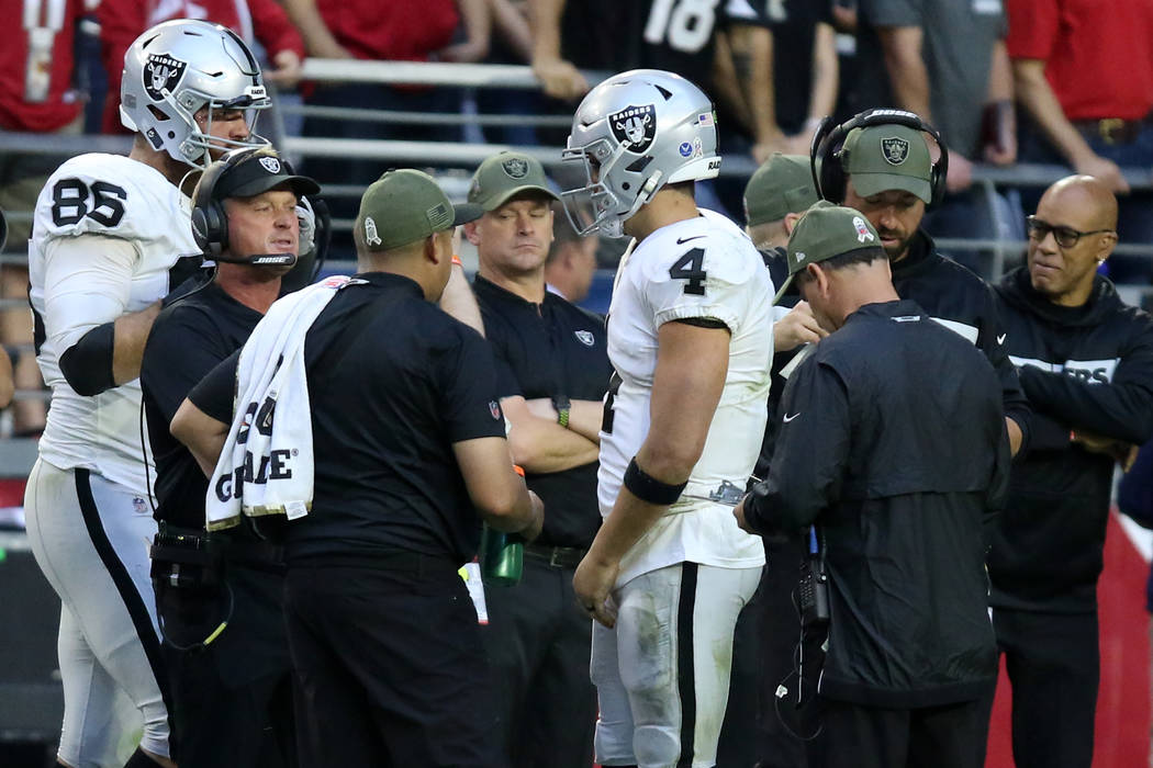 Oakland Raiders head coach Jon Gruden and quarterback Derek Carr (4) have a conversation as tig ...