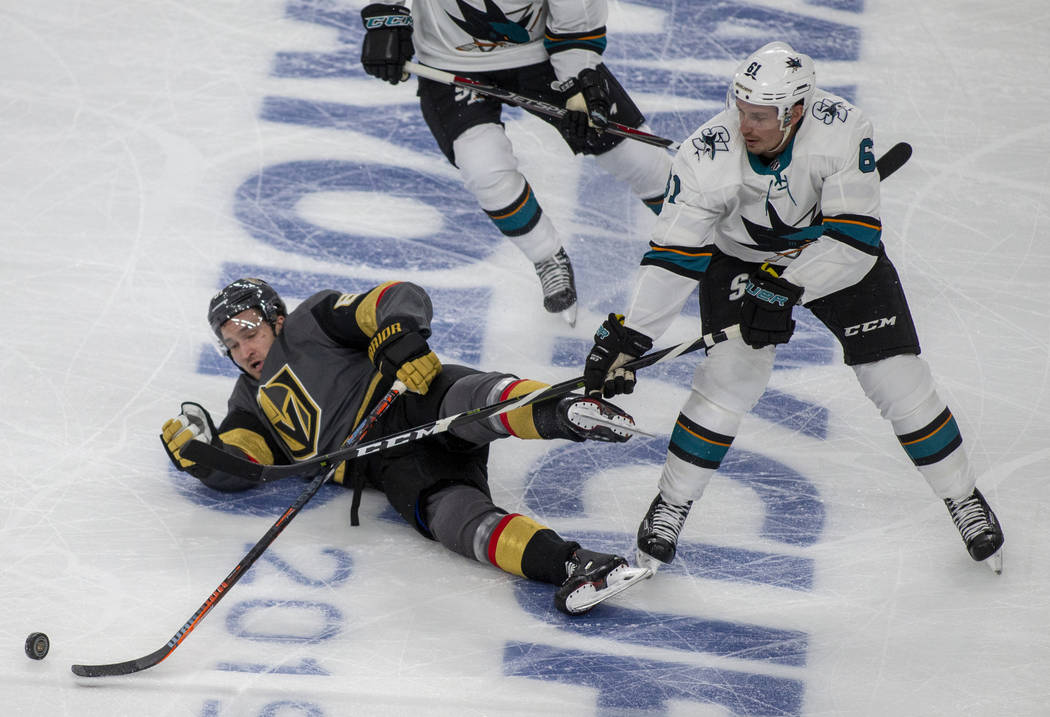 Golden Knights right wing Mark Stone (61) is taken down to the ice with San Jose Sharks defense ...