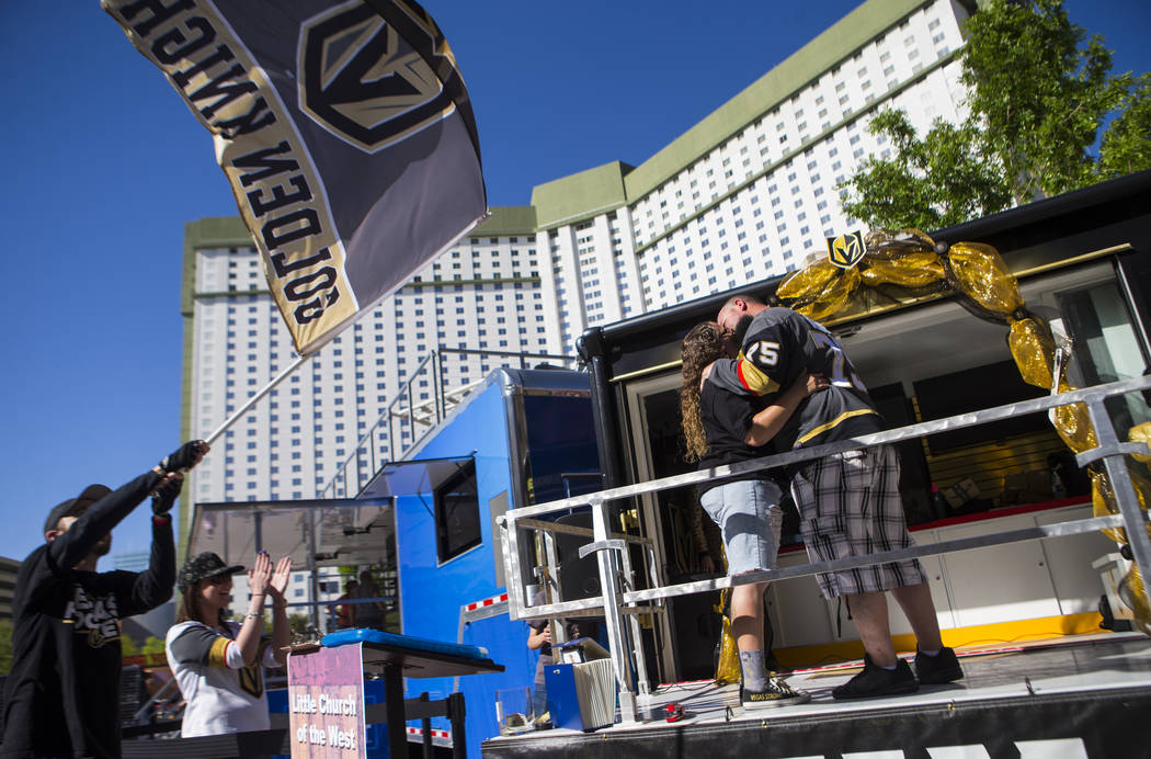 Matt Helfst, left, waves a Golden Knights flag as Crystal Mensch and Andy Mensch, both of Las V ...