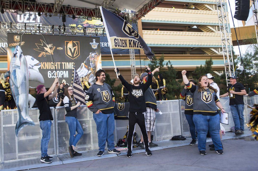 Matt Helfst, center, waves a Golden Knights flag as fans, incluing Alyce Wheeler, right, cheer ...