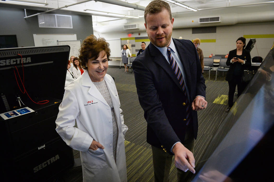 Assistant Dean of Biomedical Science Integration Neil Haycocks, right, shows Sen. Jacky Rosen, ...