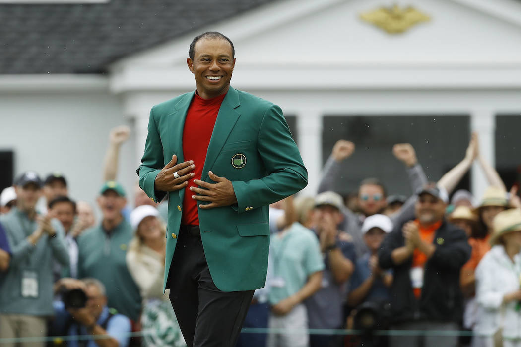 Tiger Woods smiles as he wears his green jacket after winning the Masters golf tournament Sunda ...