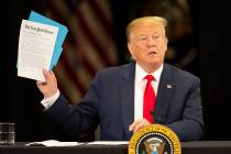 President Donald Trump holds up a New York Times article at Nuss Truck and Equipment Monday, Ap ...