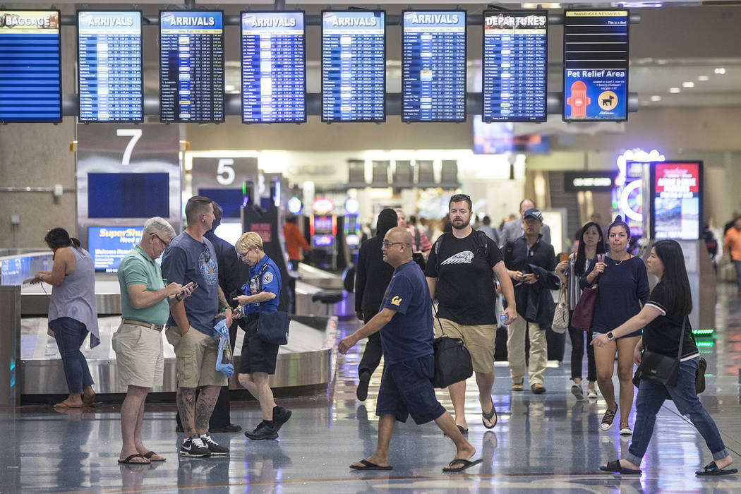 Passengers walk through Terminal 1 baggage claim at McCarran International Airport on Thursday, ...