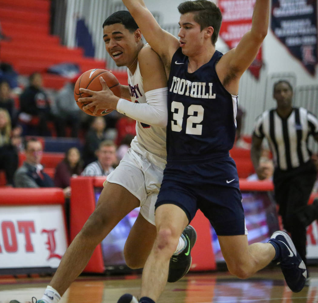 Liberty's Julian Strawther (0) runs with the ball while under pressure from Foothill's Dylan Hu ...